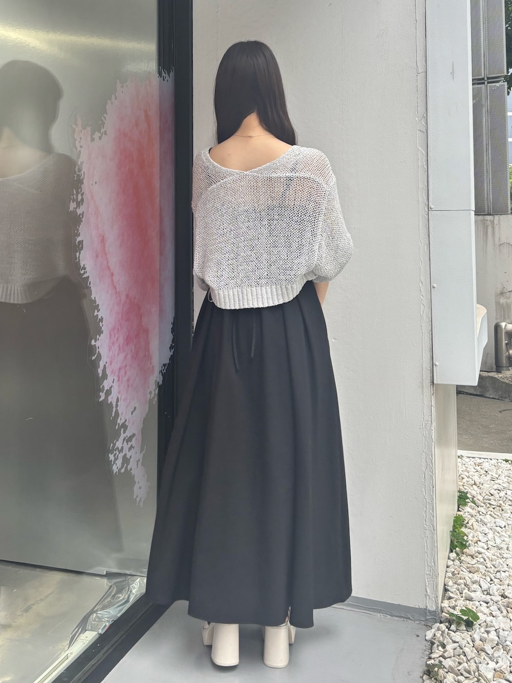 ブラック系のワンピース、ホワイト系のサンダル、ブラック系のハンドバッグを着用したレディースの夏コーディネートの5枚目の写真