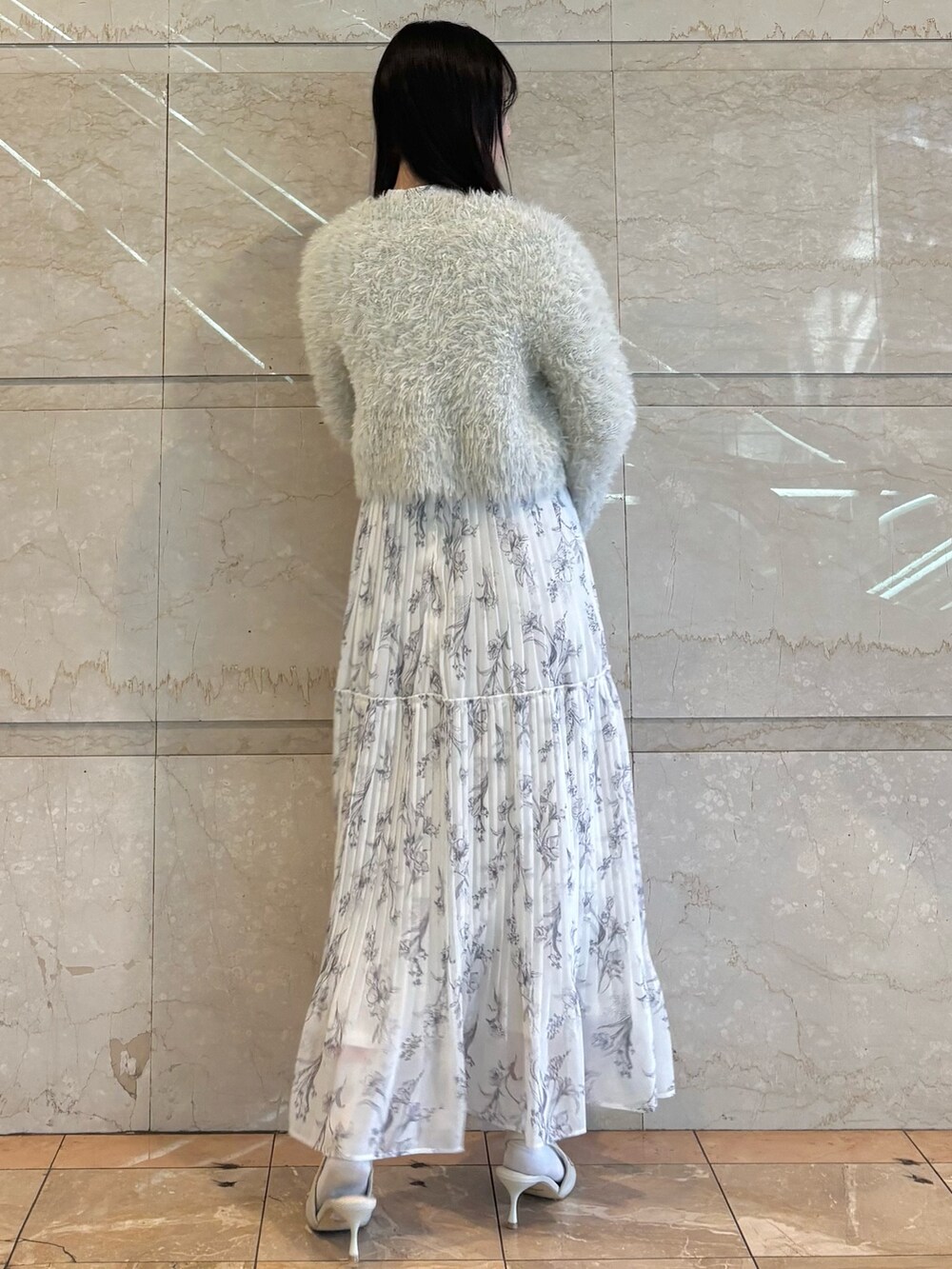 ホワイト系のワンピース、ホワイト系のパンプス、グリーン系のカーディガン/ボレロを着用したレディースの冬コーディネートの3枚目の写真