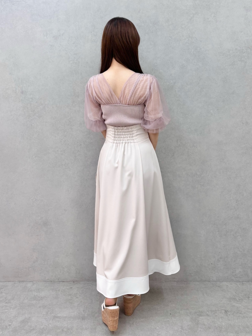 ベージュ系のスカート、ホワイト系のサンダル、ピンク系のニット/セーターを着用したレディースの春コーディネートの4枚目の写真