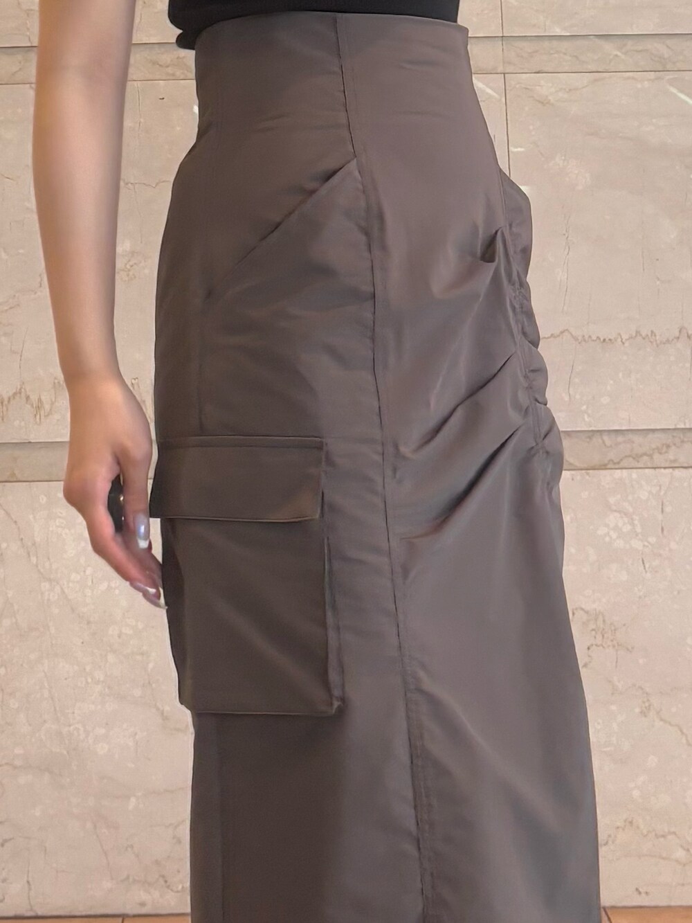 ブラウン系のスカート、ブラウン系のサンダル、ブラック系のニット/セーターを着用したレディースの夏コーディネートの8枚目の写真