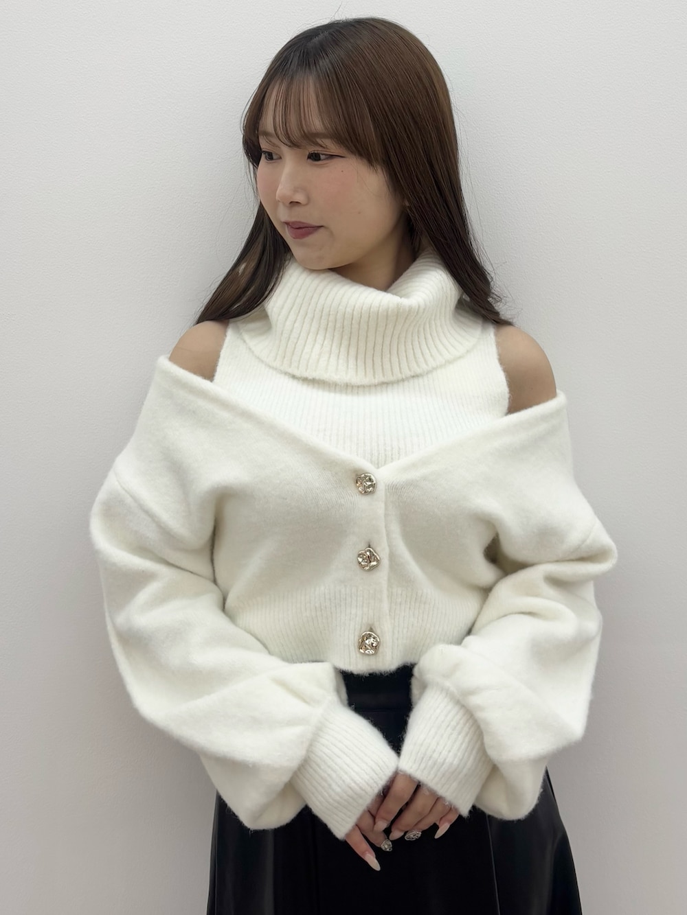 ホワイト系のニット/セーター、ブラック系のスカート、ブラック系のブーツを着用したレディースの冬コーディネートの6枚目の写真