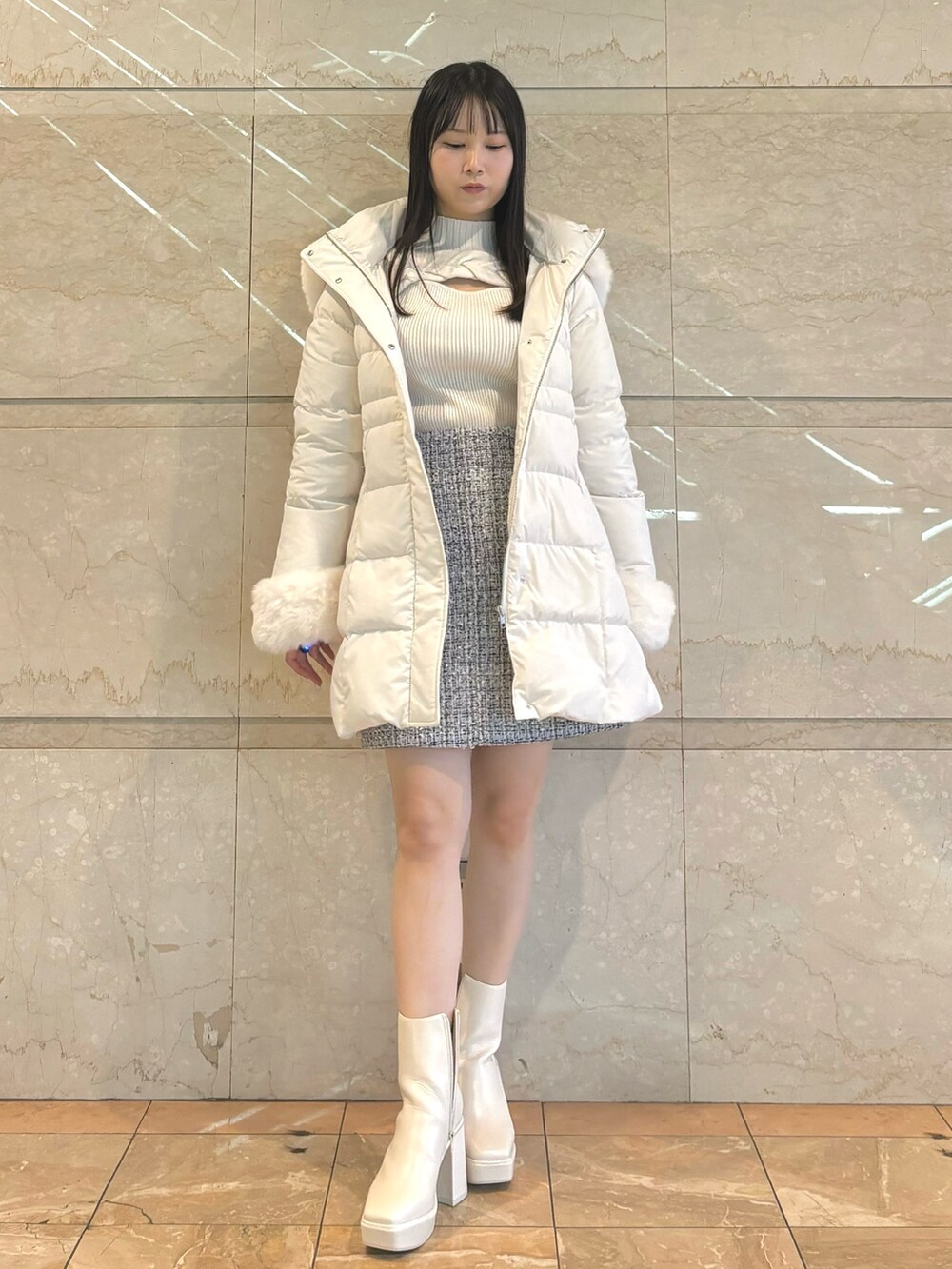 ホワイト系のダウンジャケット/コート、ホワイト系のブーツ、ホワイト系のスカートを着用したレディースの秋コーディネートの2枚目の写真