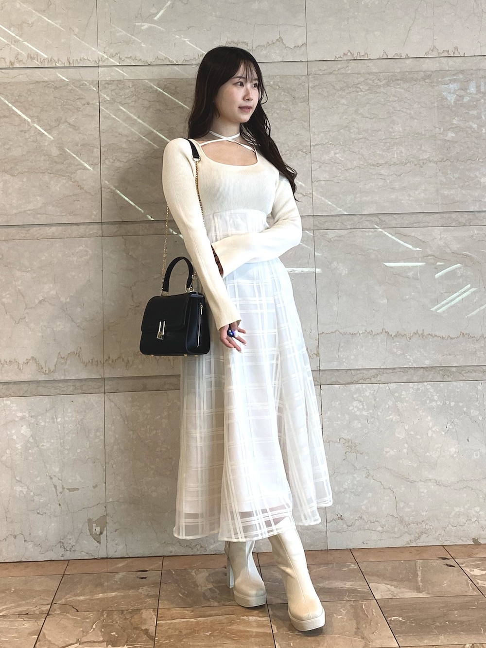 ホワイト系のワンピース、ホワイト系のブーツ、ブラック系のショルダーバッグを着用したレディースの秋コーディネートの5枚目の写真