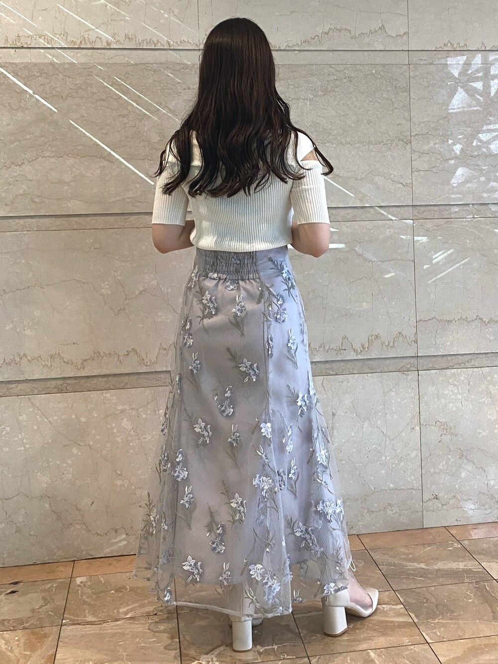 ホワイト系のニット/セーター、ブルー系のスカート、ホワイト系のブーツを着用したレディースの夏コーディネートの4枚目の写真