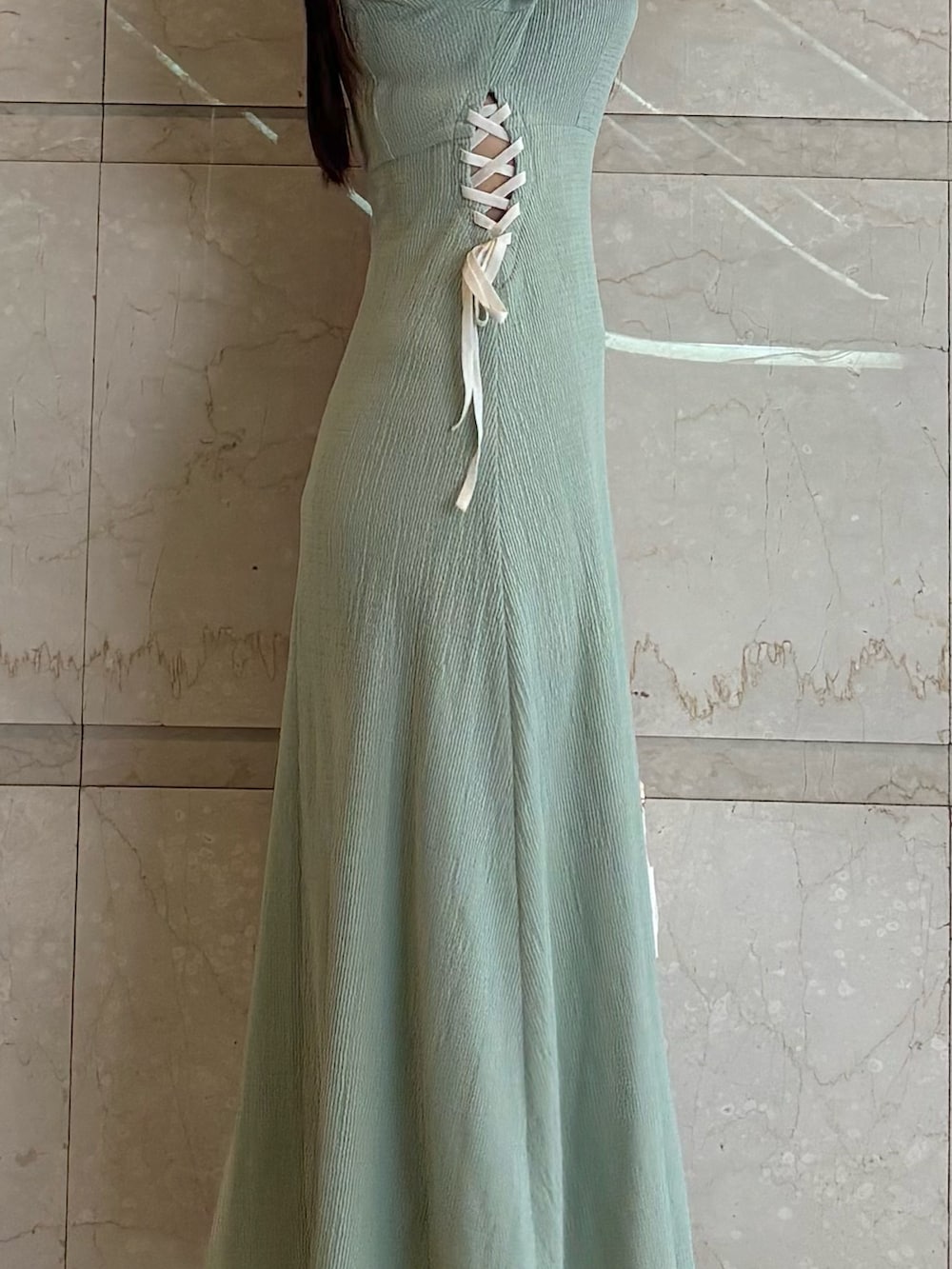 グリーン系のワンピース、ブラック系のパンプス、ホワイト系のショルダーバッグを着用したレディースの夏コーディネートの5枚目の写真