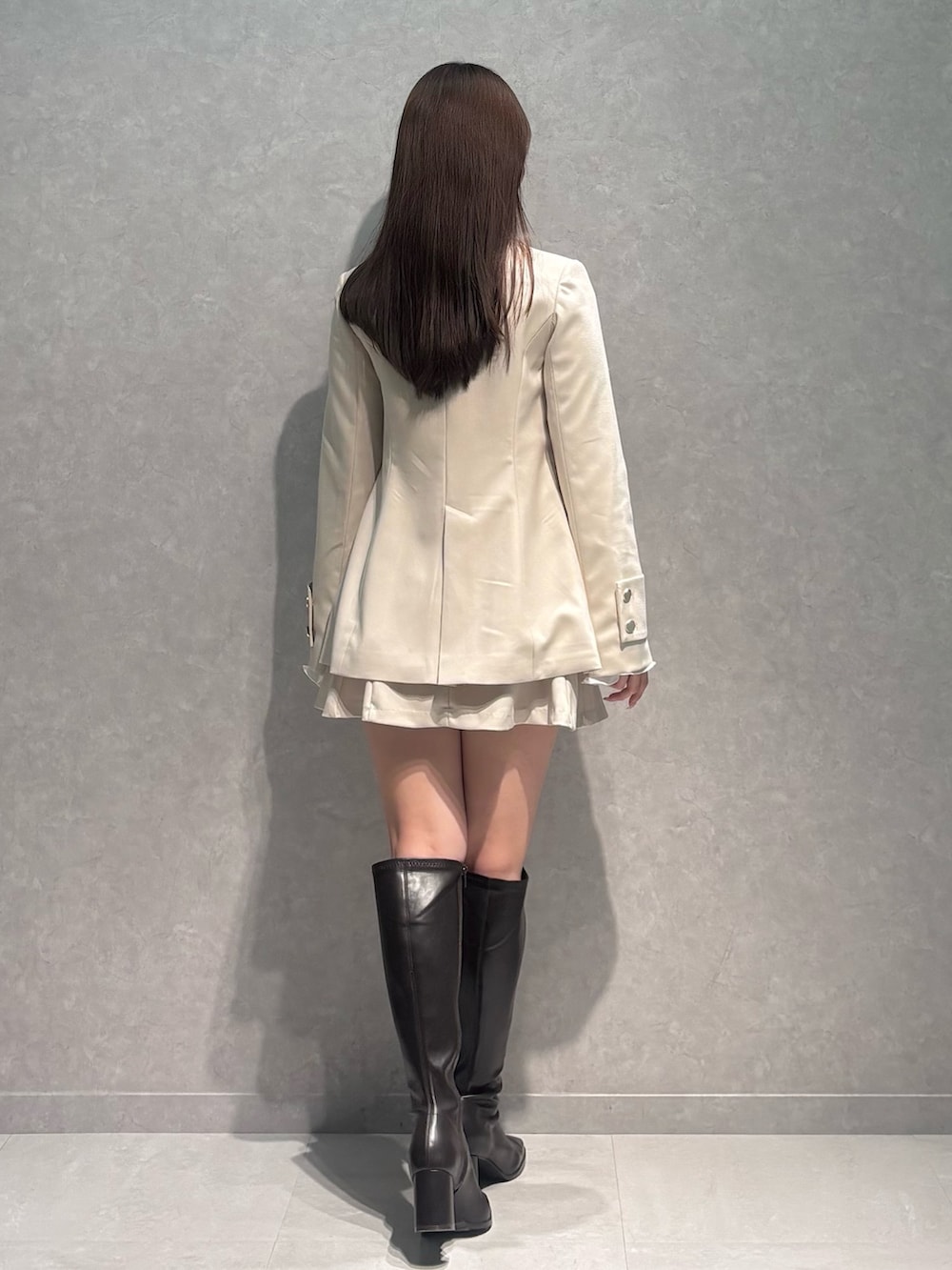 ホワイト系のスカート、ホワイト系のテーラードジャケット、ベージュ系のニット/セーターを着用したレディースの冬コーディネートの5枚目の写真