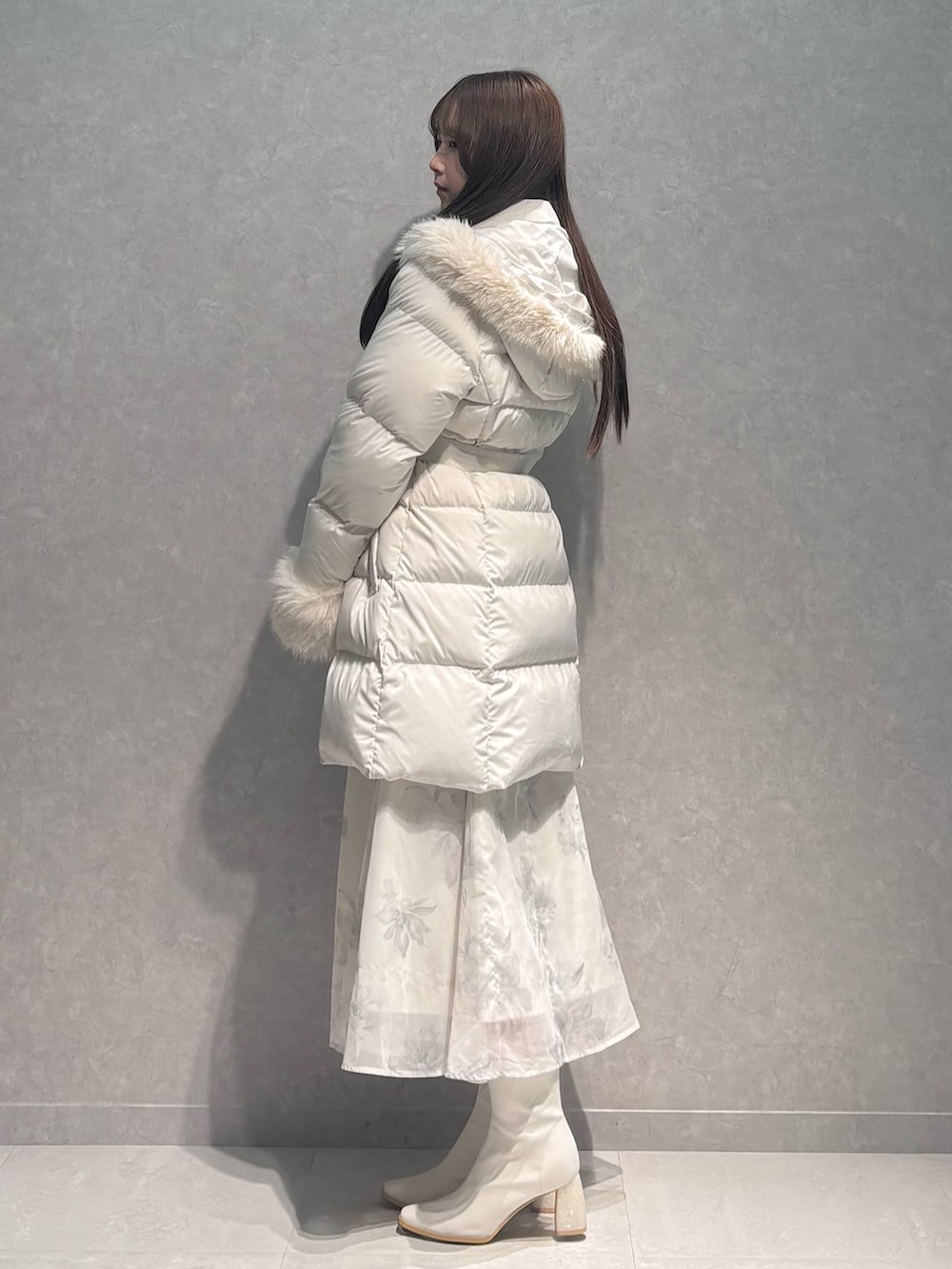 ベージュ系のワンピース、ホワイト系のダウンジャケット/コート、ホワイト系のブーツを着用したレディースの秋コーディネートの4枚目の写真