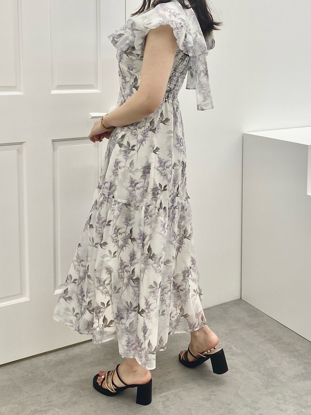 ホワイト系のサンダル、パープル系のワンピースを着用したレディースの春コーディネートの3枚目の写真