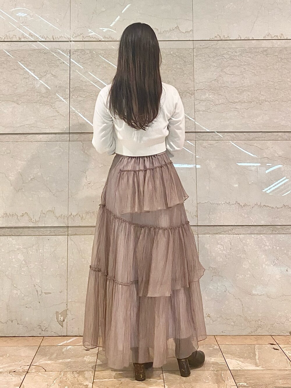 ブラウン系のスカート、ホワイト系のカーディガン/ボレロ、ブラウン系のブーツを着用したレディースの冬コーディネートの4枚目の写真