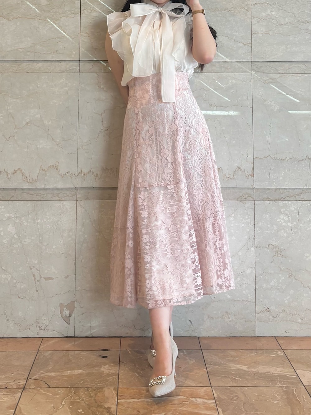 ピンク系のスカート、ベージュ系のパンプス、ホワイト系のシャツ/ブラウスを着用したレディースの夏コーディネートの3枚目の写真