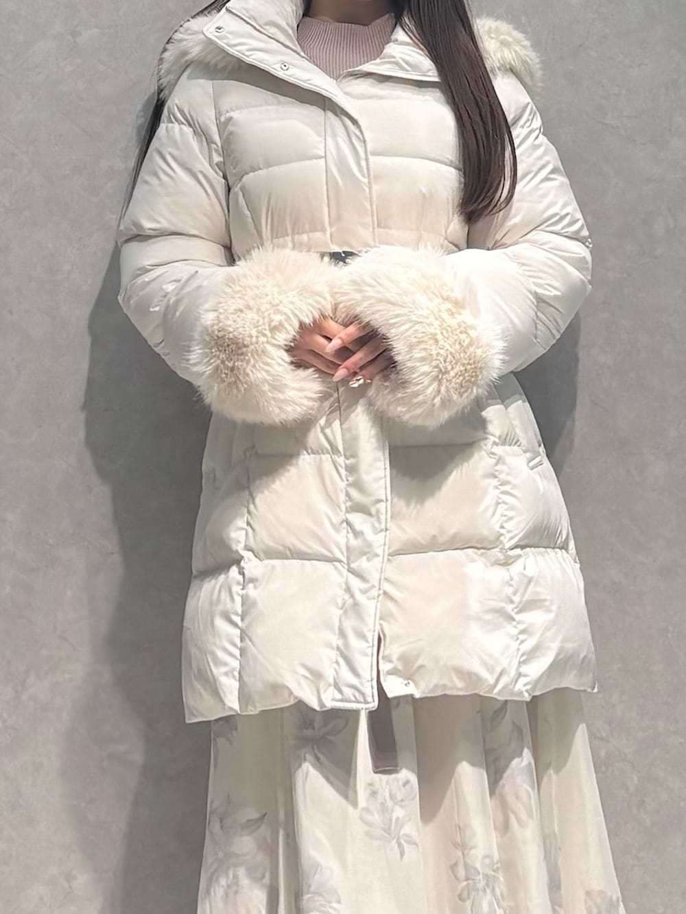 ベージュ系のワンピース、ホワイト系のダウンジャケット/コート、ホワイト系のブーツを着用したレディースの秋コーディネートの6枚目の写真