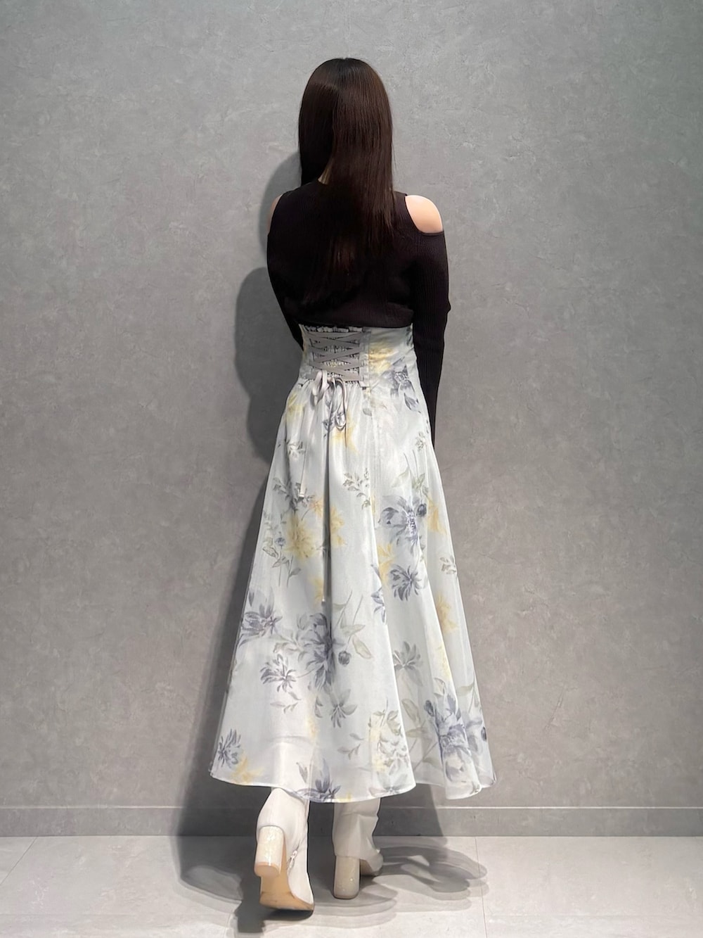 グリーン系のスカート、ブラウン系のニット/セーター、ホワイト系のブーツを着用したレディースの冬コーディネートの5枚目の写真