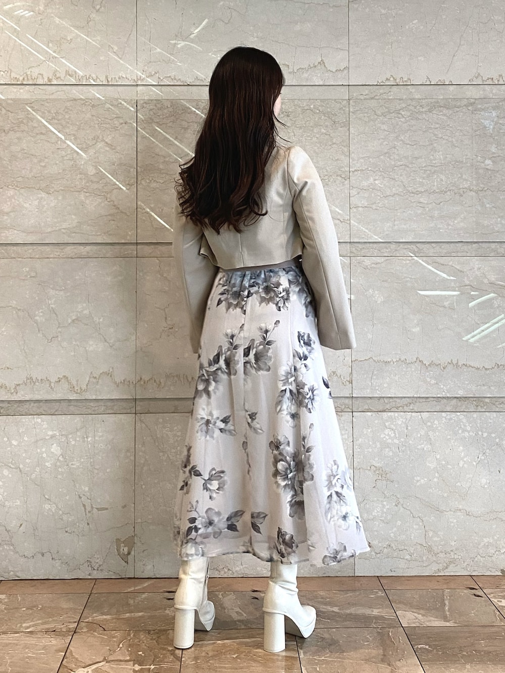 ベージュ系のワンピース、ホワイト系のブーツ、ベージュ系のテーラードジャケットを着用したレディースの秋コーディネートの3枚目の写真