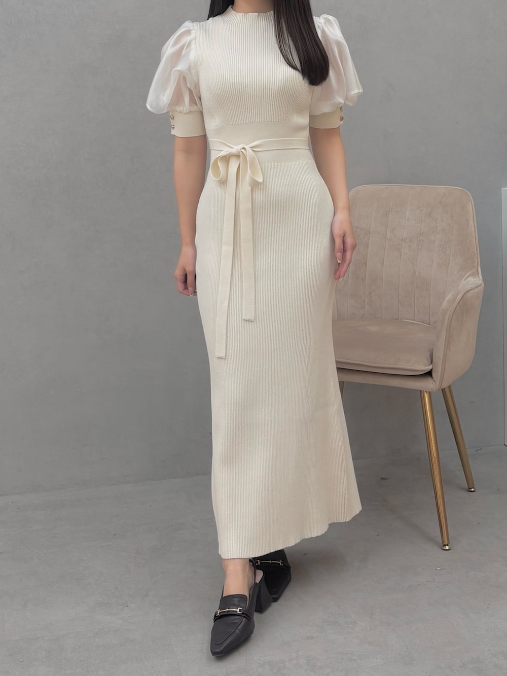 ブラウン系のパンプス、ホワイト系のワンピースを着用したレディースの冬コーディネートの2枚目の写真