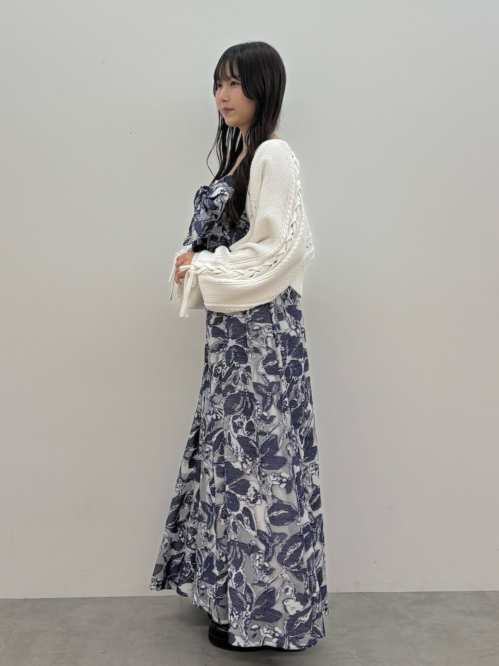 ブルー系のワンピース、ブラウン系のブーツ、ホワイト系のカーディガン/ボレロを着用したレディースの秋コーディネートの3枚目の写真