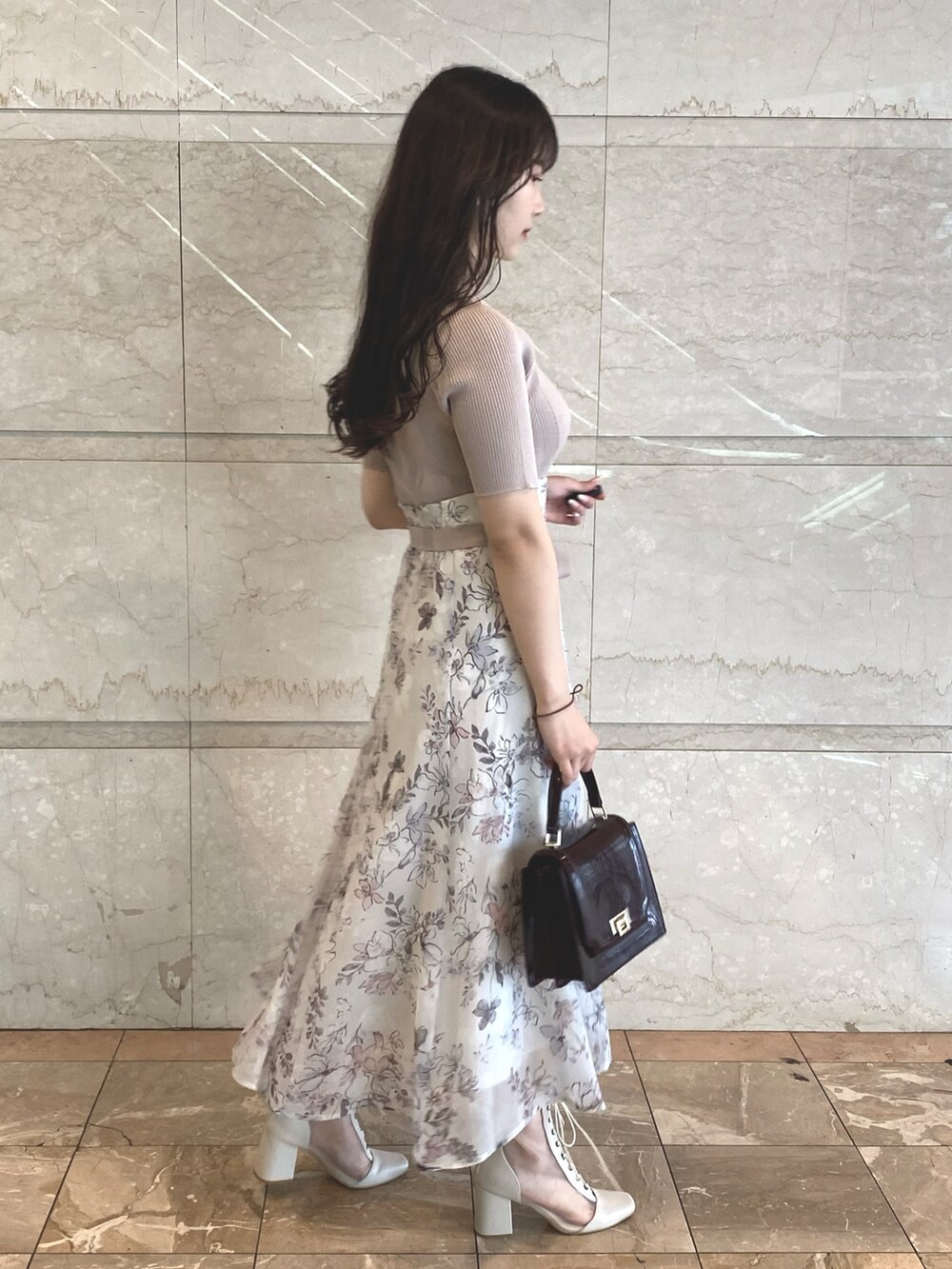 ベージュ系のワンピース、レッド系のハンドバッグ、ホワイト系のブーツを着用したレディースの夏コーディネートの7枚目の写真