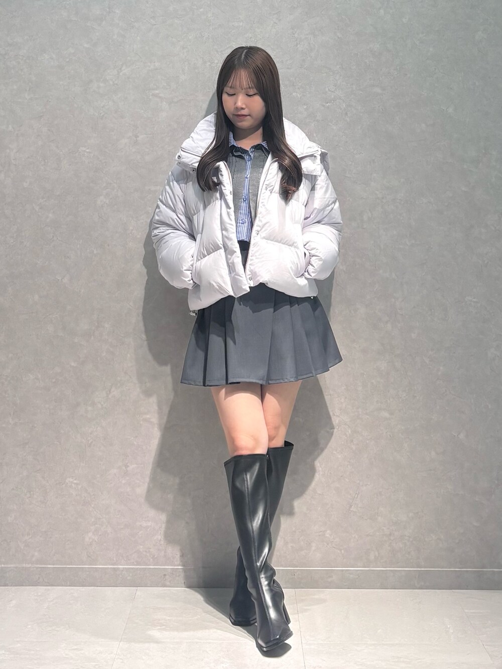 グレー系のスカート、ブラック系のブーツ、グレー系のカーディガン/ボレロを着用したレディースの秋コーディネートの3枚目の写真