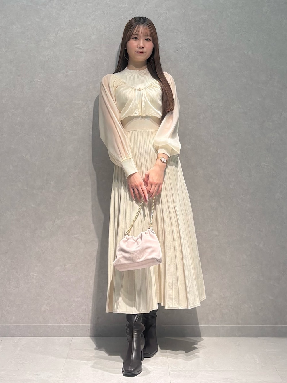 ホワイト系のワンピース、ホワイト系のダウンジャケット/コート、ブラウン系のブーツを着用したレディースの冬コーディネートの2枚目の写真