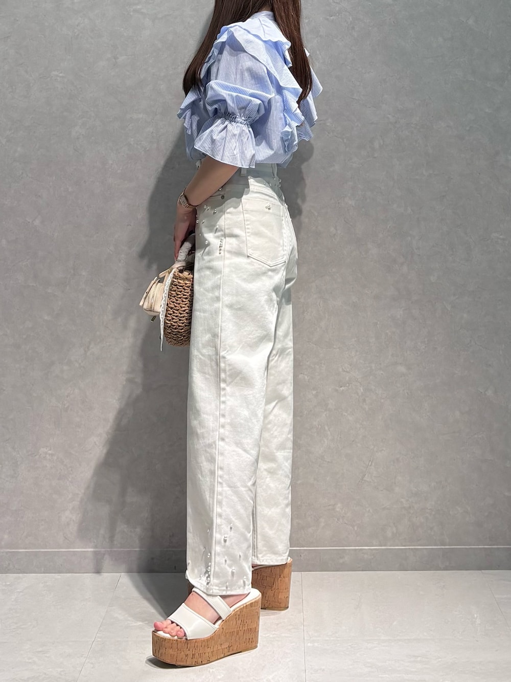 ホワイト系のデニムパンツ、ブルー系のシャツ/ブラウス、ベージュ系のハンドバッグを着用したレディースの春コーディネートの4枚目の写真