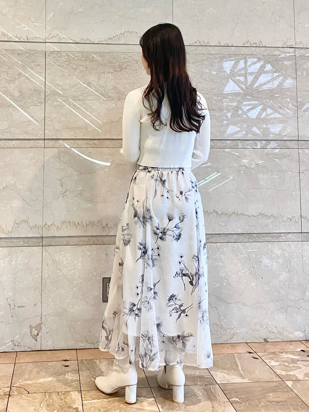 ホワイト系のスカート、ホワイト系のカーディガン/ボレロ、ホワイト系のブーツを着用したレディースの冬コーディネートの3枚目の写真