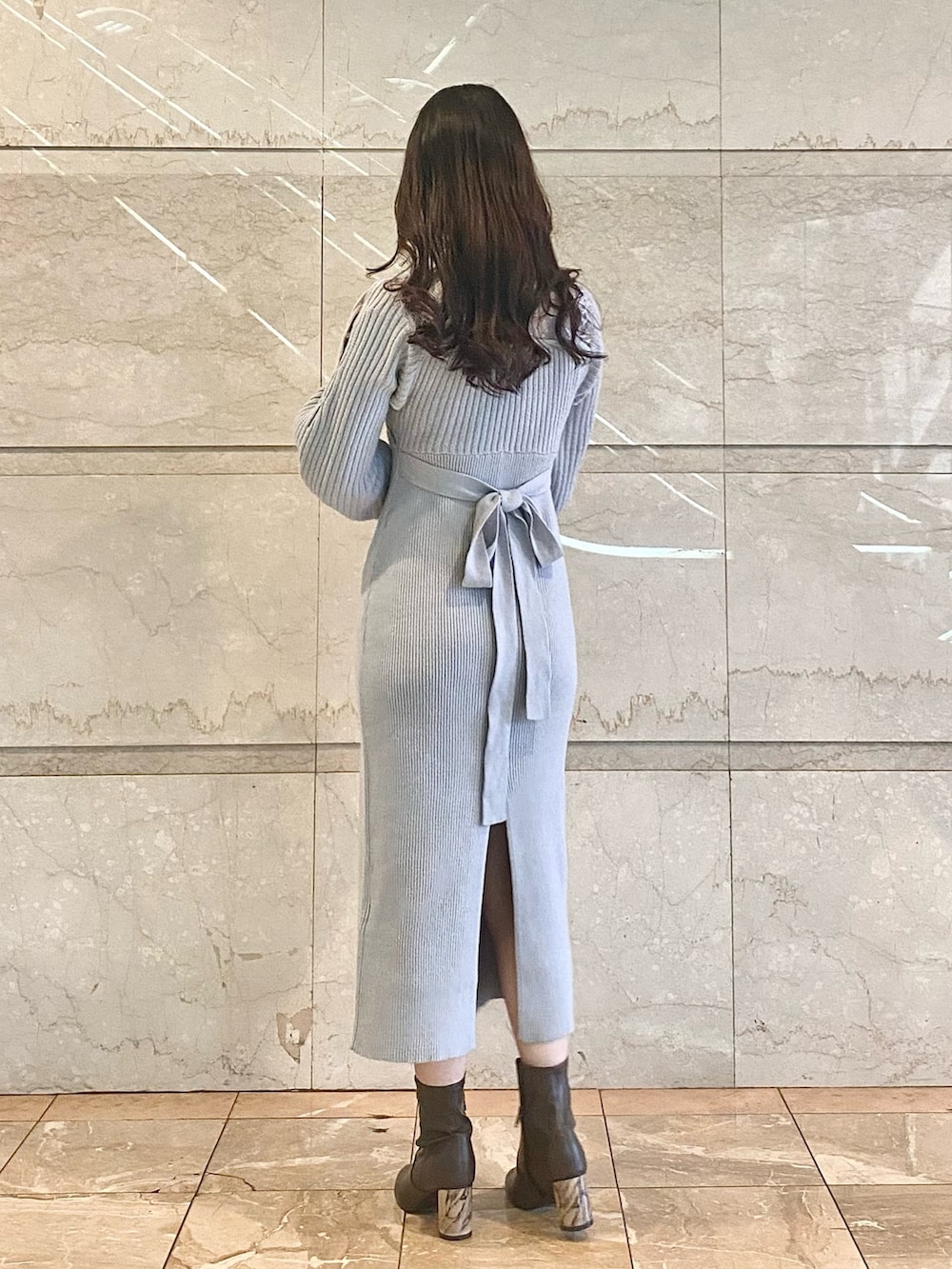 グレー系のワンピース、ブラウン系のブーツを着用したレディースの冬コーディネートの3枚目の写真