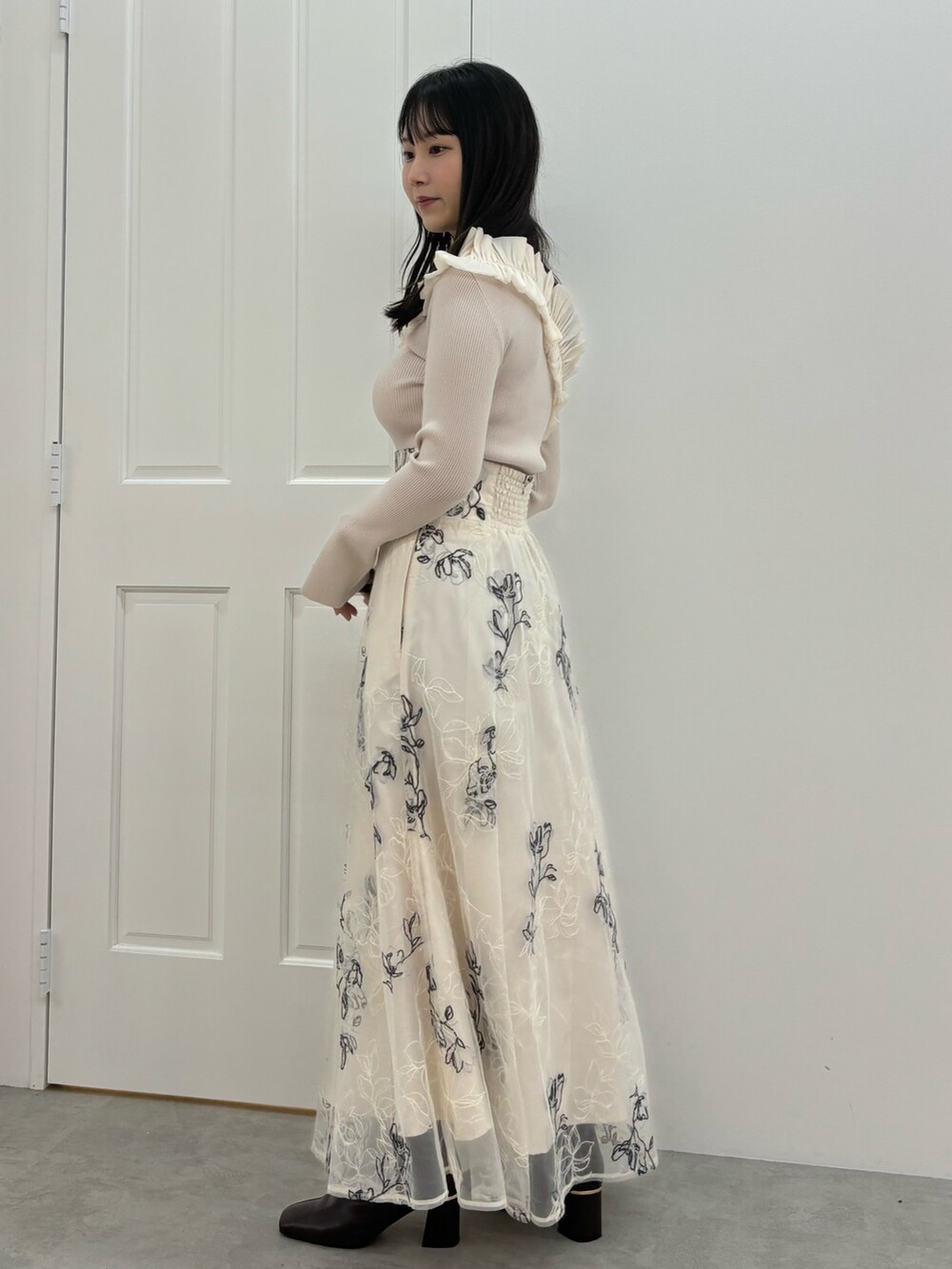 ホワイト系のスカート、ブラウン系のブーツ、ホワイト系のニット/セーターを着用したレディースの秋コーディネートの3枚目の写真