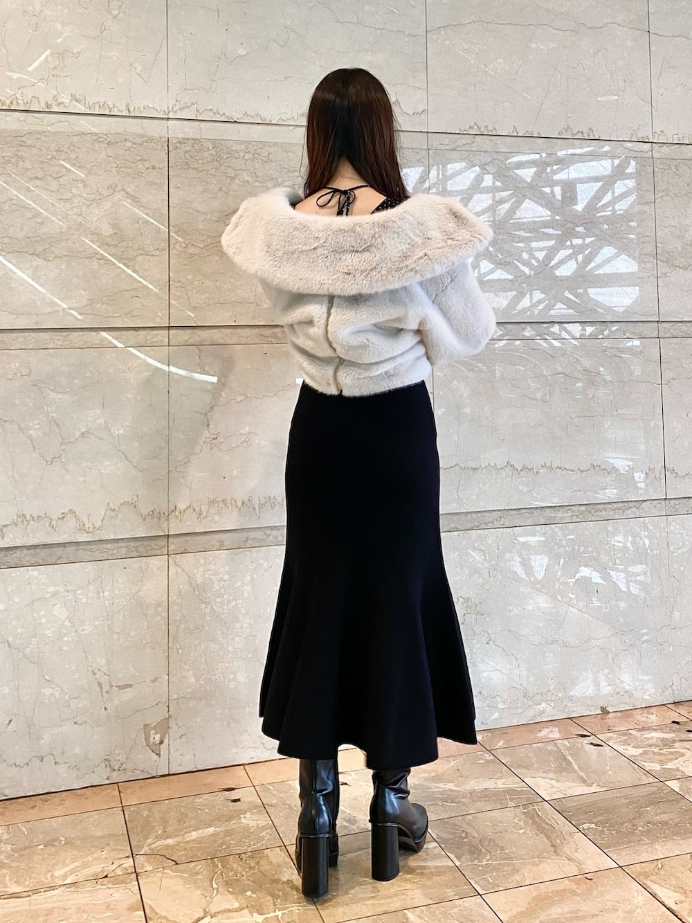 ホワイト系のその他アウター、ブラック系のワンピース、ブラック系のブーツを着用したレディースの秋コーディネートの3枚目の写真