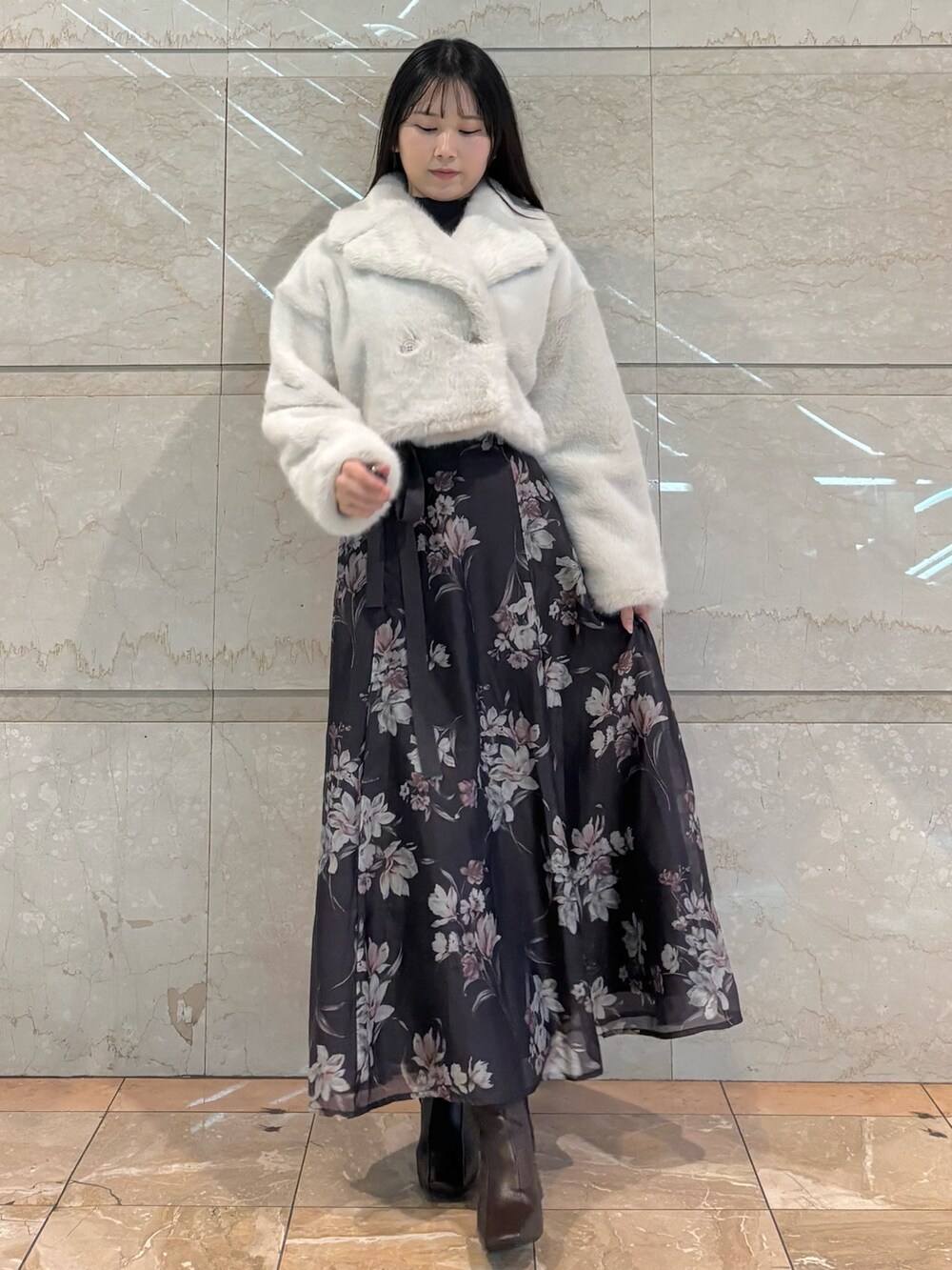 グレー系のワンピース、ブラウン系のブーツ、ホワイト系のその他アウターを着用したレディースの冬コーディネートの4枚目の写真