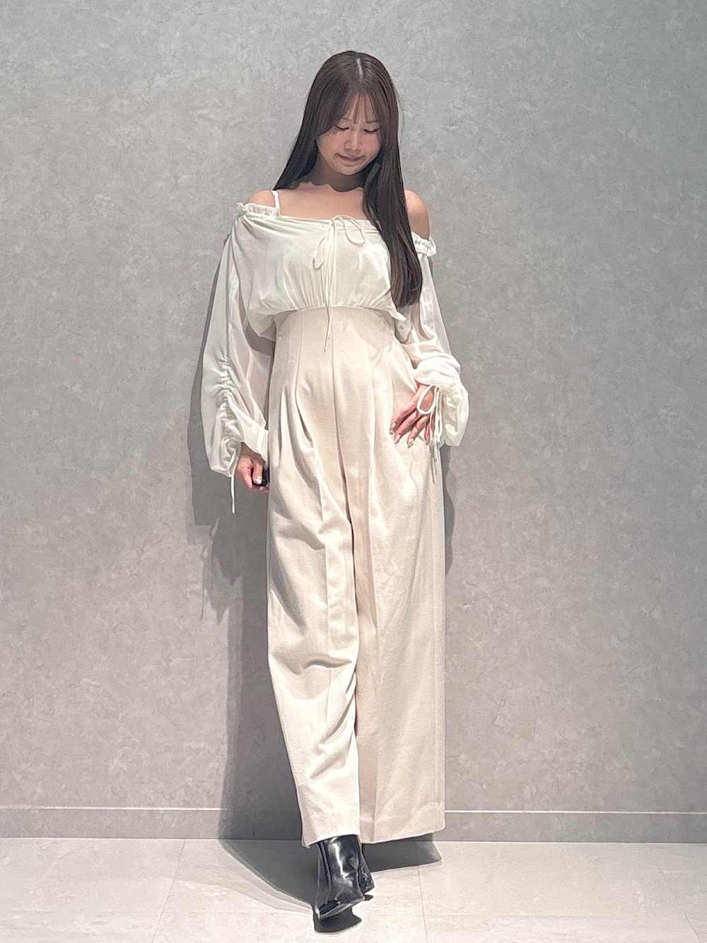 ホワイト系のワンピース、ブラック系のブーツを着用したレディースの秋コーディネートの2枚目の写真