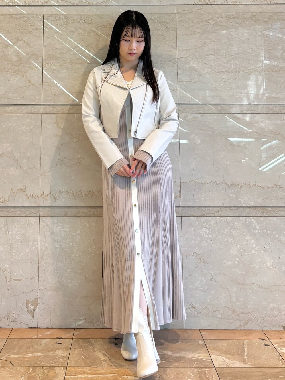 ピンク系のワンピース、ホワイト系のブーツ、ホワイト系のライダースジャケットを着用したレディースの冬コーディネートの4枚目の写真