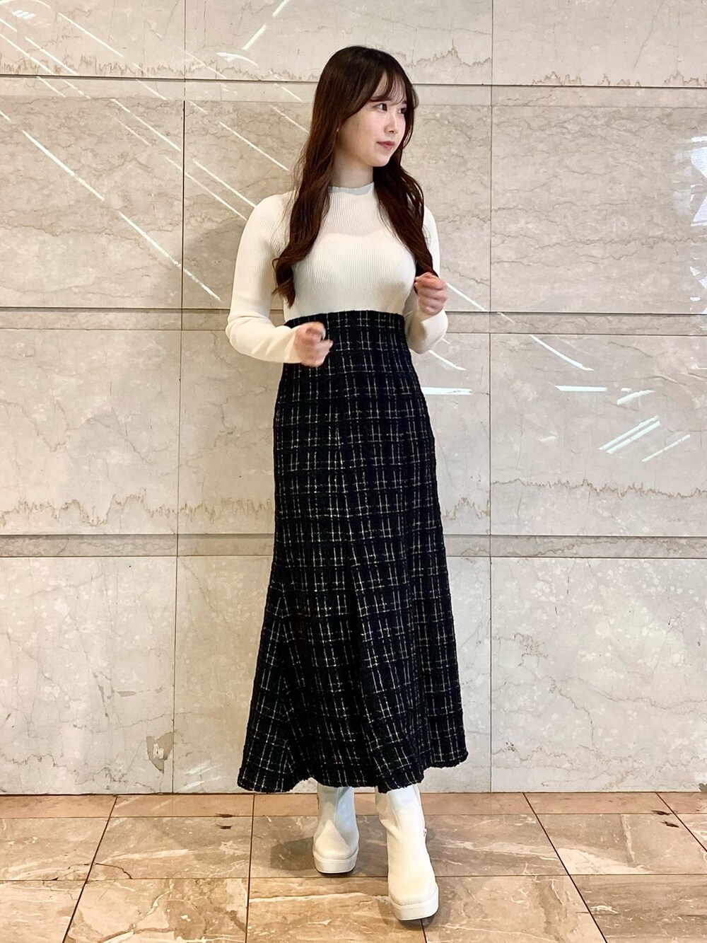 ブラック系のワンピース、ホワイト系のブーツを着用したレディースの秋コーディネートの2枚目の写真