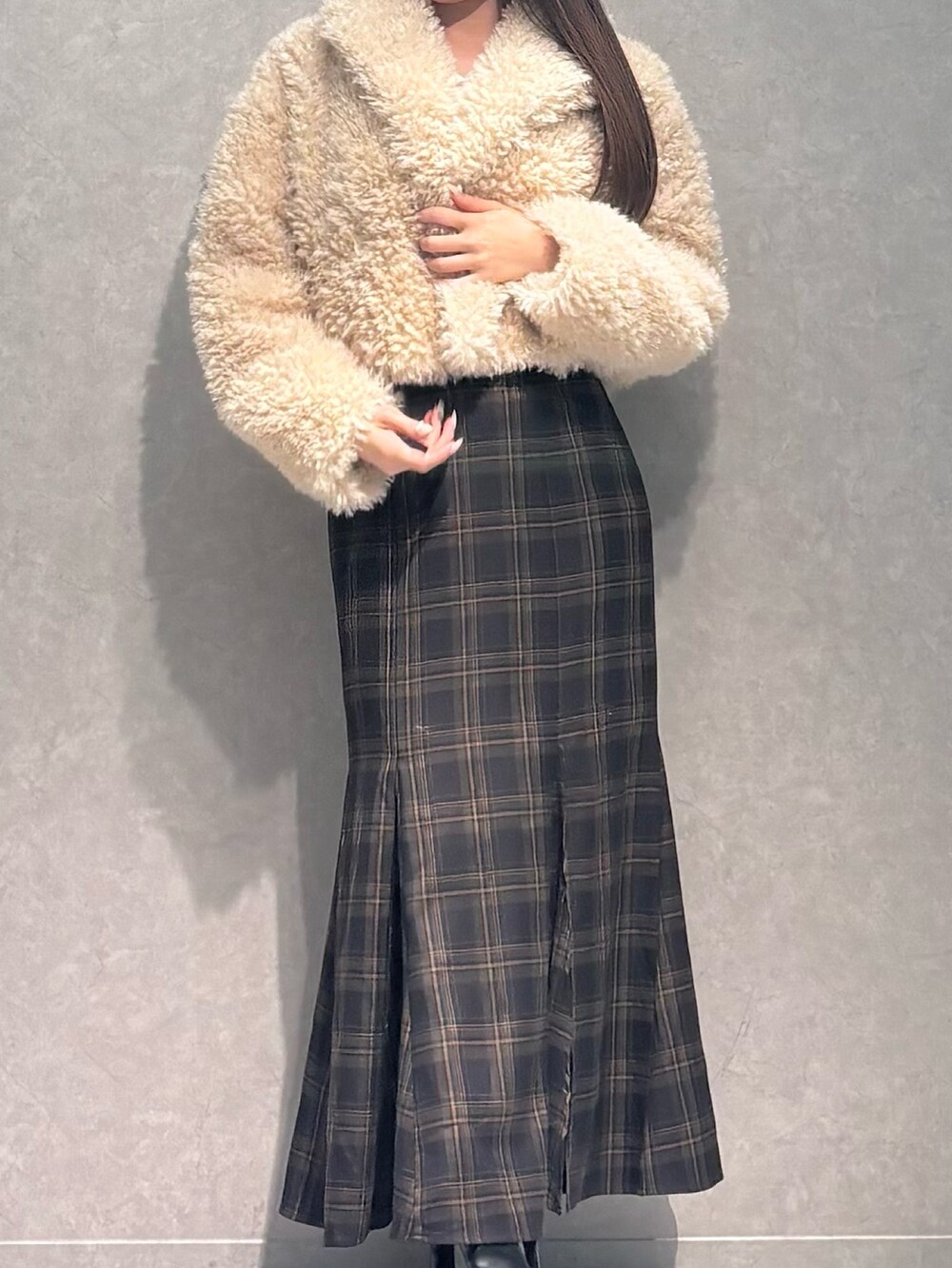 ブラウン系のスカート、ホワイト系のニット/セーター、ベージュ系のその他アウターを着用したレディースの秋コーディネートの3枚目の写真