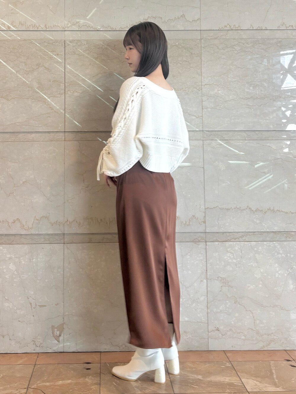 ブラウン系のワンピース、ホワイト系のブーツ、ホワイト系のカーディガン/ボレロを着用したレディースの秋コーディネートの3枚目の写真