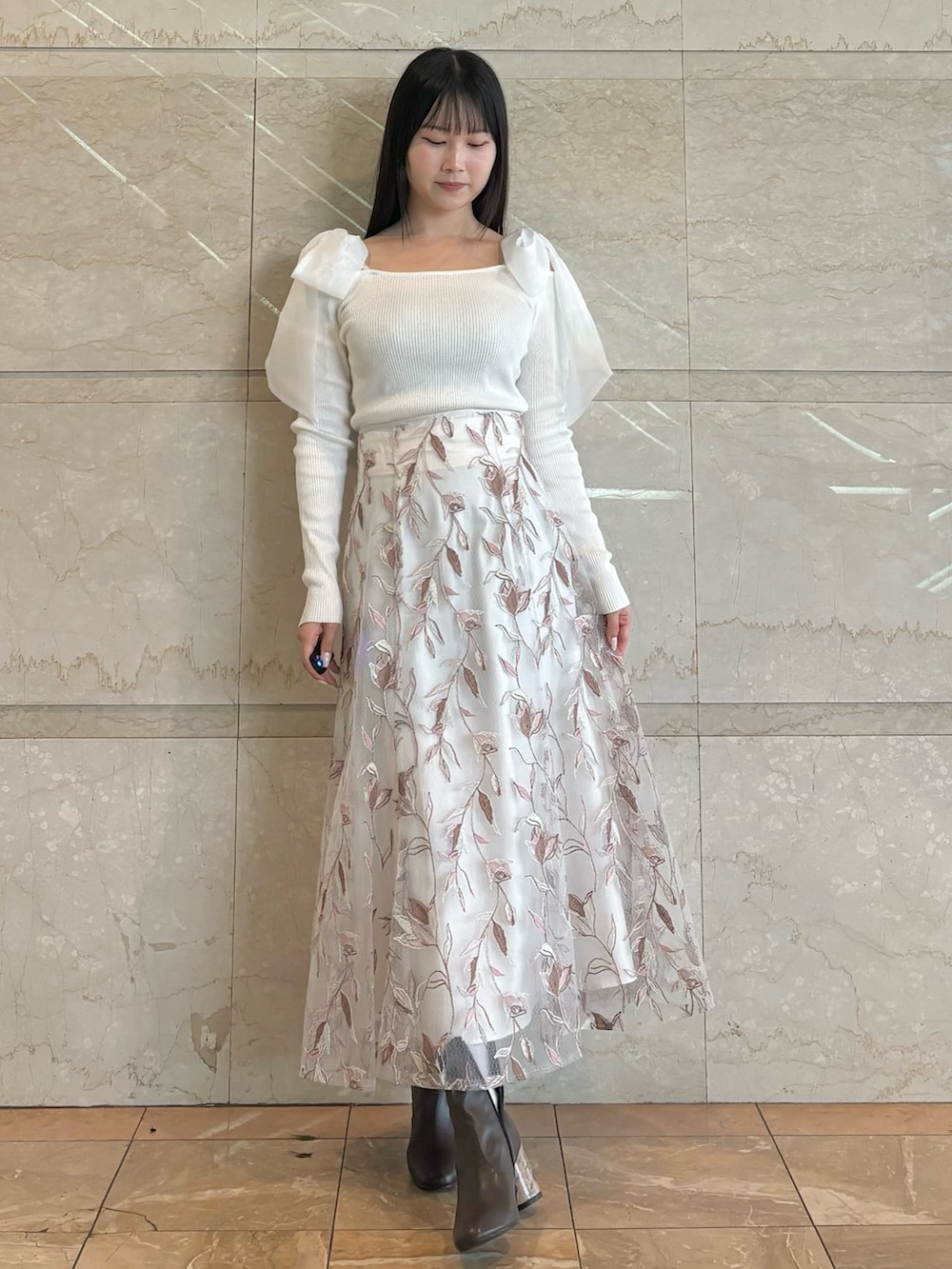 ホワイト系のスカート、ブラウン系のブーツ、ホワイト系のニット/セーターを着用したレディースの秋コーディネートの3枚目の写真