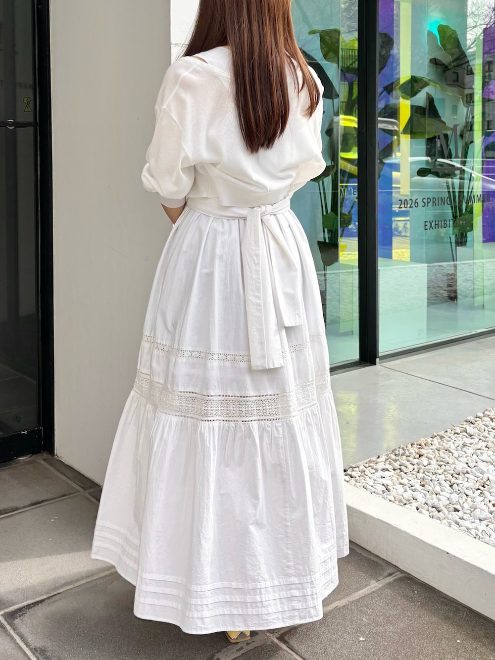 ホワイト系のワンピース、ホワイト系のカーディガン/ボレロ、イエロー系のサンダルを着用したレディースの春コーディネートの5枚目の写真