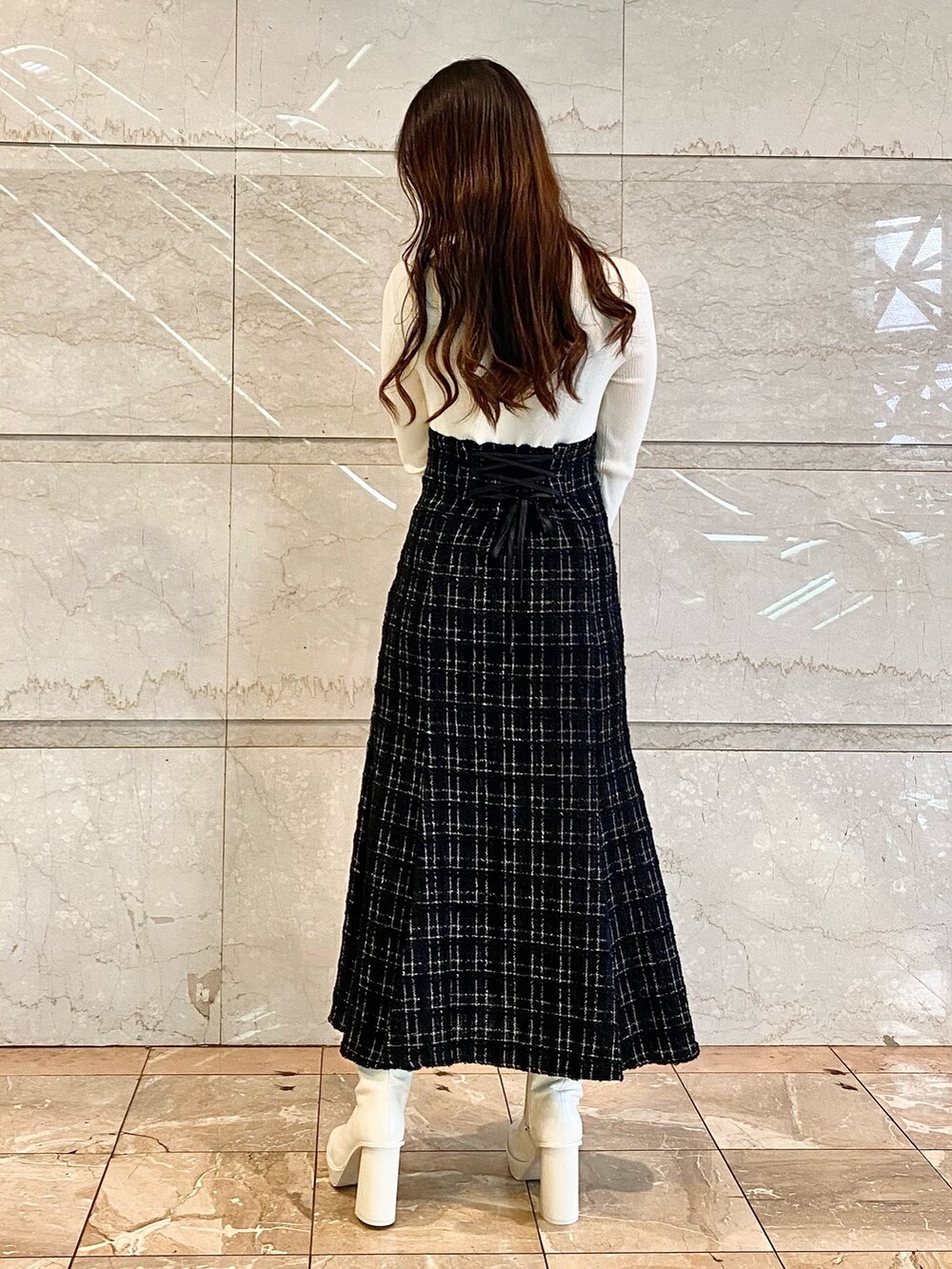 ブラック系のワンピース、ホワイト系のブーツを着用したレディースの秋コーディネートの5枚目の写真