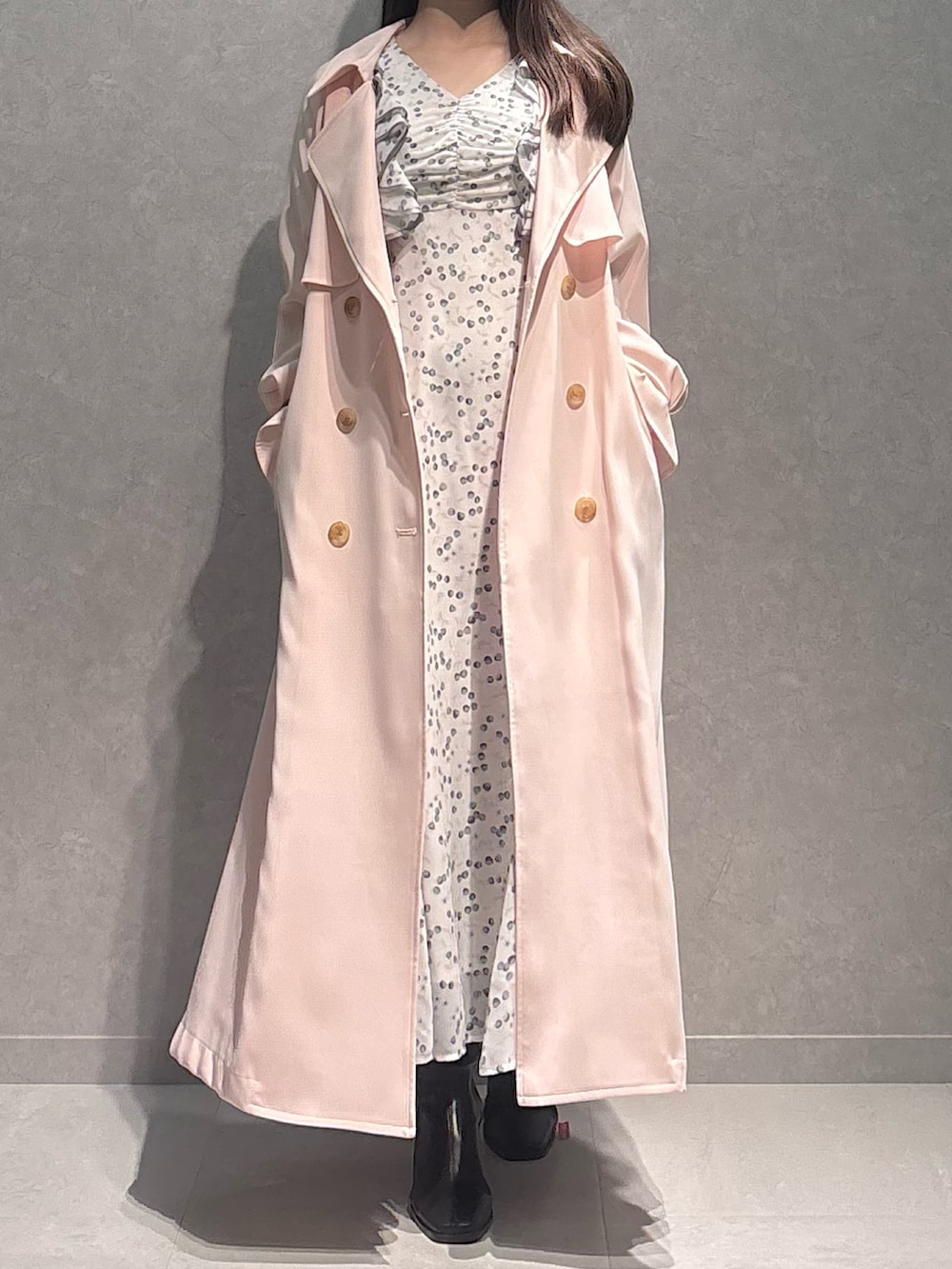 ホワイト系のワンピース、ピンク系のトレンチコート、ブラウン系のブーツを着用したレディースの春コーディネートの2枚目の写真