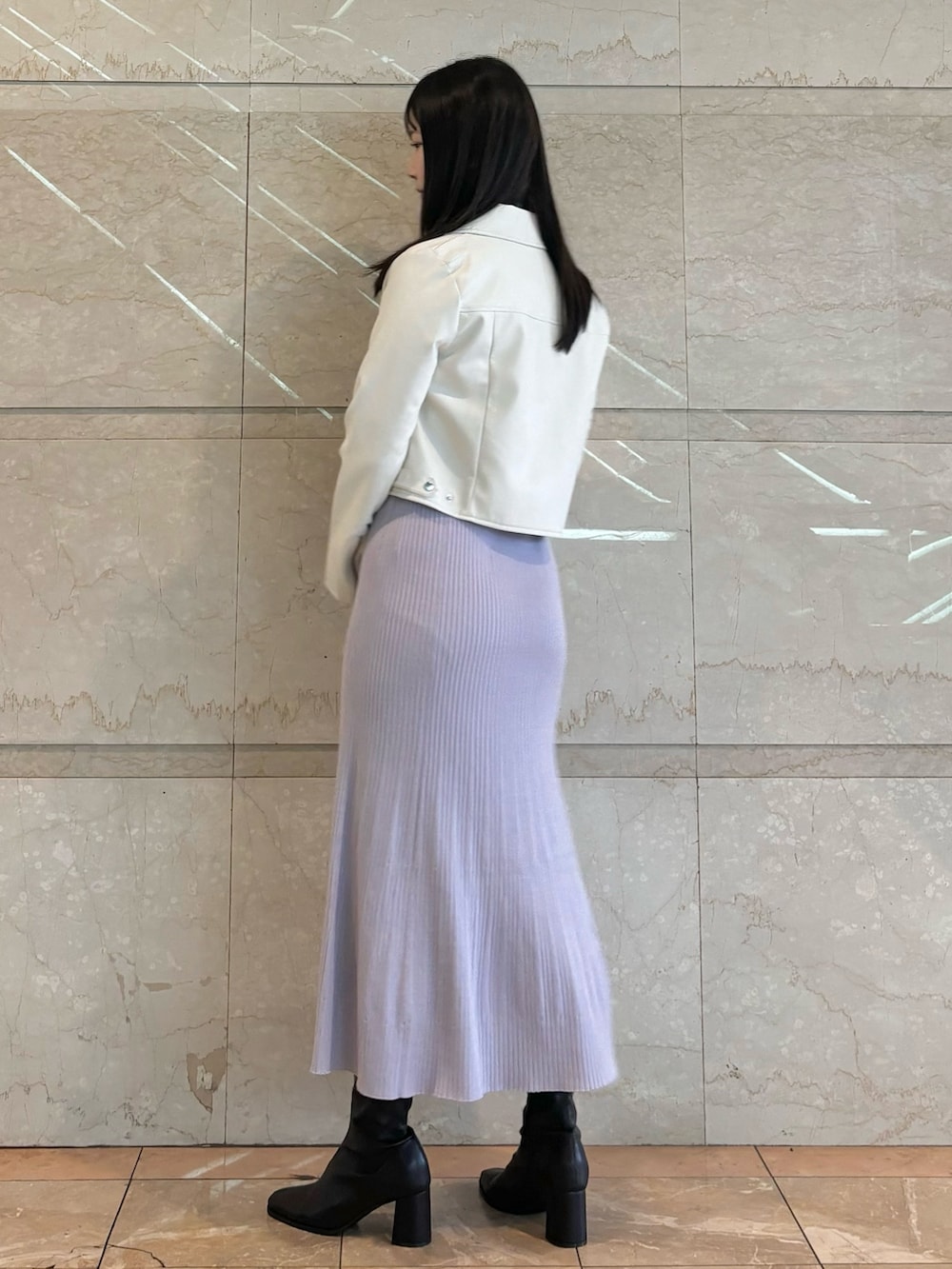 パープル系のワンピース、ホワイト系のライダースジャケット、ブラウン系のブーツを着用したレディースの秋コーディネートの2枚目の写真