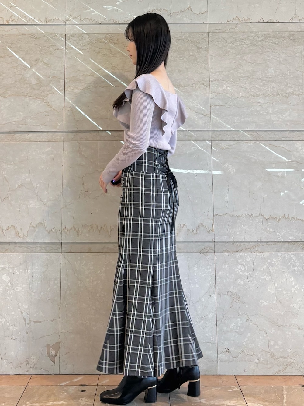 ピンク系のハンドバッグ、ブラック系のブーツ、その他のスカートを着用したレディースの冬コーディネートの2枚目の写真