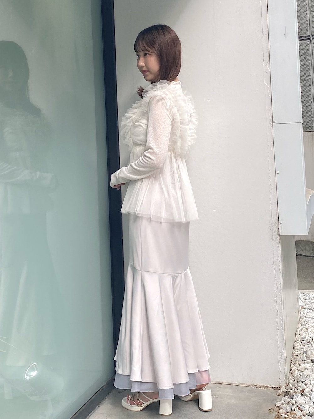 グレー系のスカート、ホワイト系のサンダル、ホワイト系のシャツ/ブラウスを着用したレディースの夏コーディネートの3枚目の写真