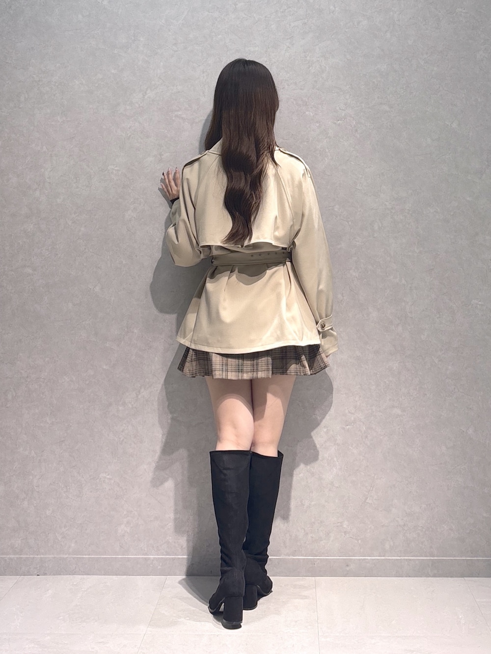 ベージュ系のスカート、ブラウン系のTシャツ/カットソー、ベージュ系のトレンチコートを着用したレディースの秋コーディネートの6枚目の写真