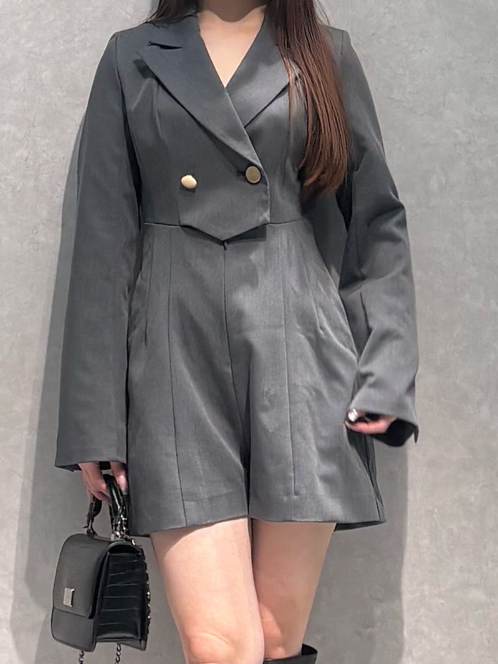 グレー系のつなぎ/オールインワン、ブラウン系のブーツ、ブラック系のハンドバッグを着用したレディースの冬コーディネートの3枚目の写真