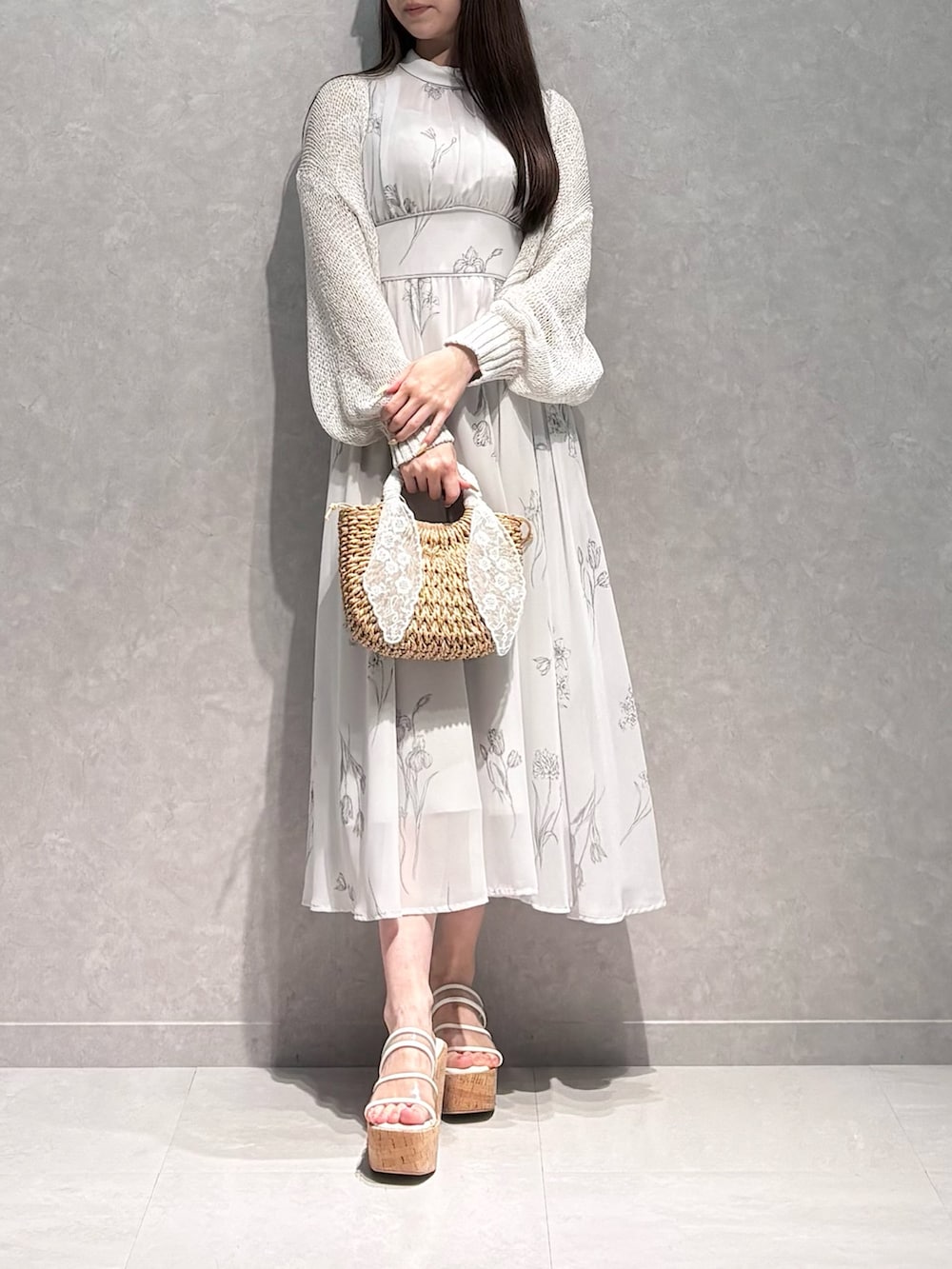 グレー系のワンピース、その他のサンダル、ベージュ系のハンドバッグを着用したレディースの夏コーディネートの3枚目の写真