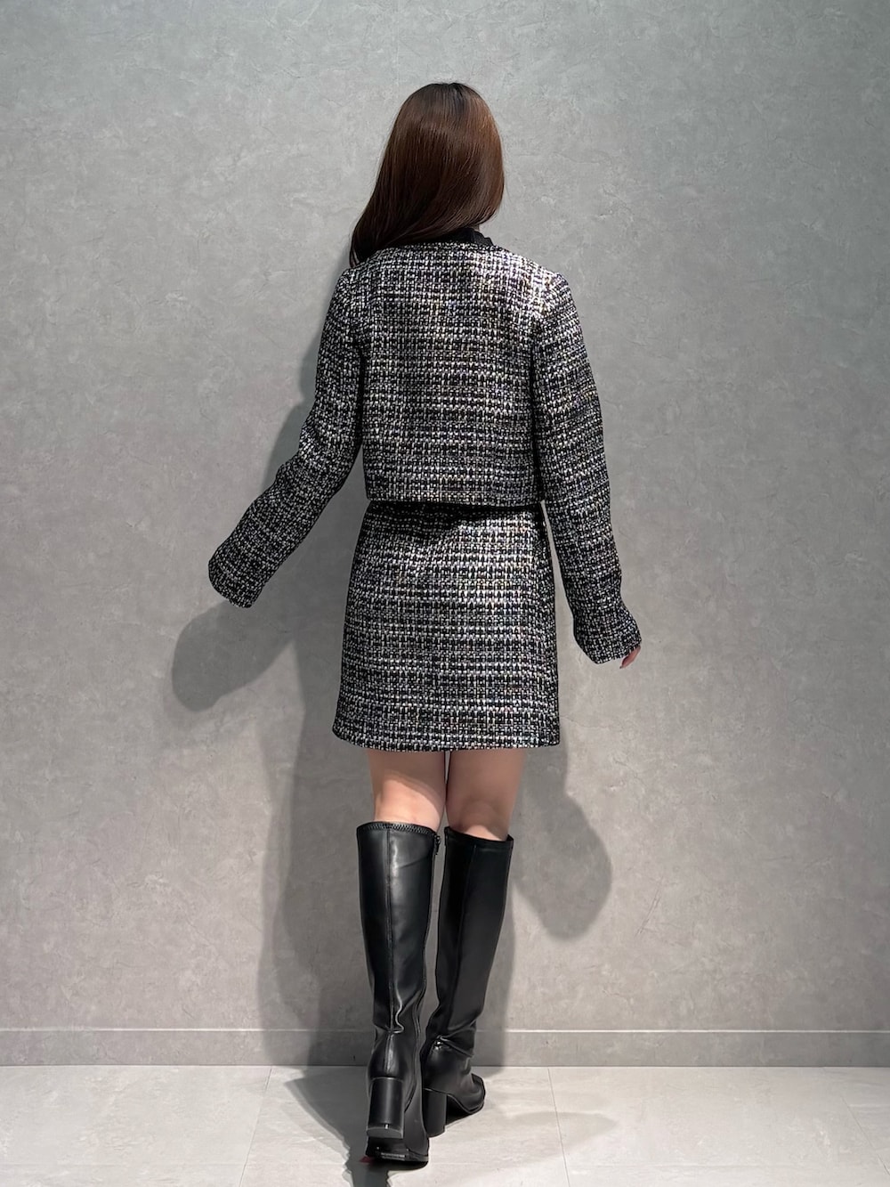 ブラック系のスカート、ブラック系のニット/セーター、ブラック系のテーラードジャケットを着用したレディースの春コーディネートの5枚目の写真