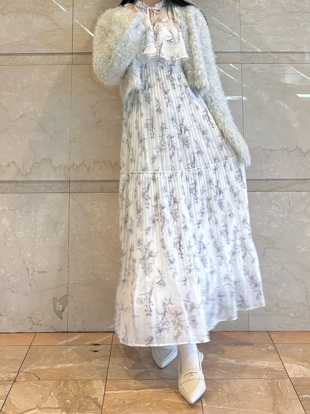 ホワイト系のワンピース、ホワイト系のパンプス、グリーン系のカーディガン/ボレロを着用したレディースの冬コーディネートの2枚目の写真