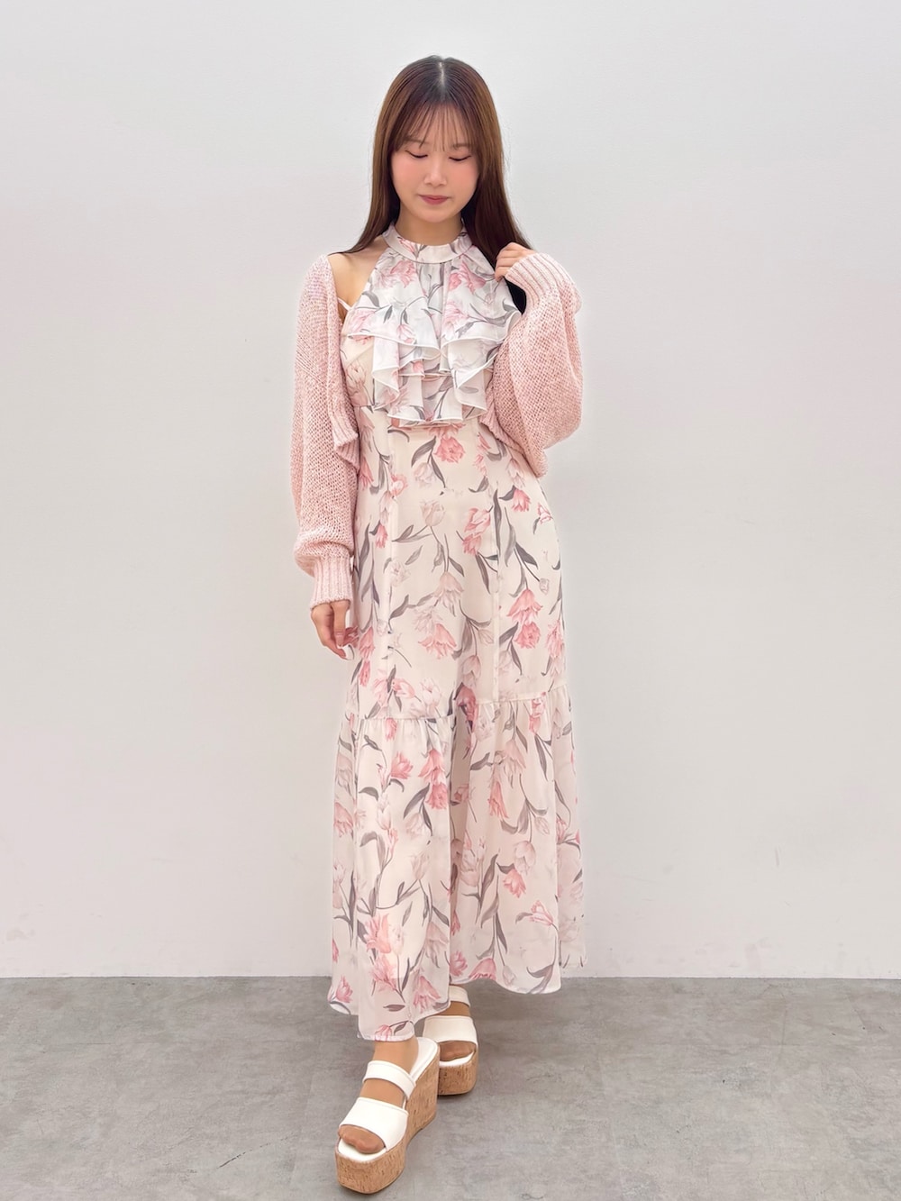 ピンク系のワンピース、ピンク系のカーディガン/ボレロ、ホワイト系のサンダルを着用したレディースの春コーディネートの2枚目の写真