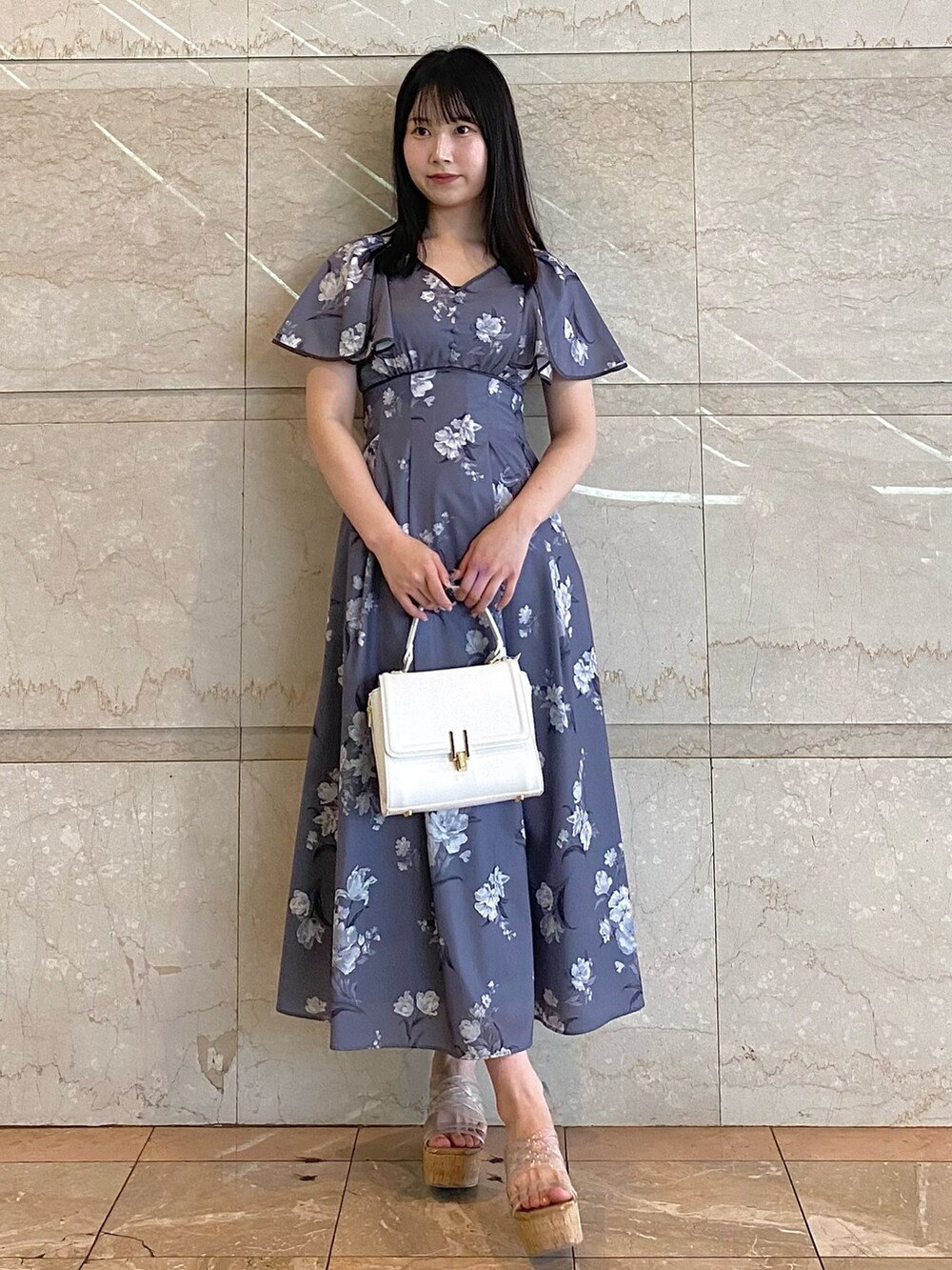 ホワイト系のハンドバッグ、グレー系のワンピース、その他のサンダルを着用したレディースの夏コーディネートの5枚目の写真