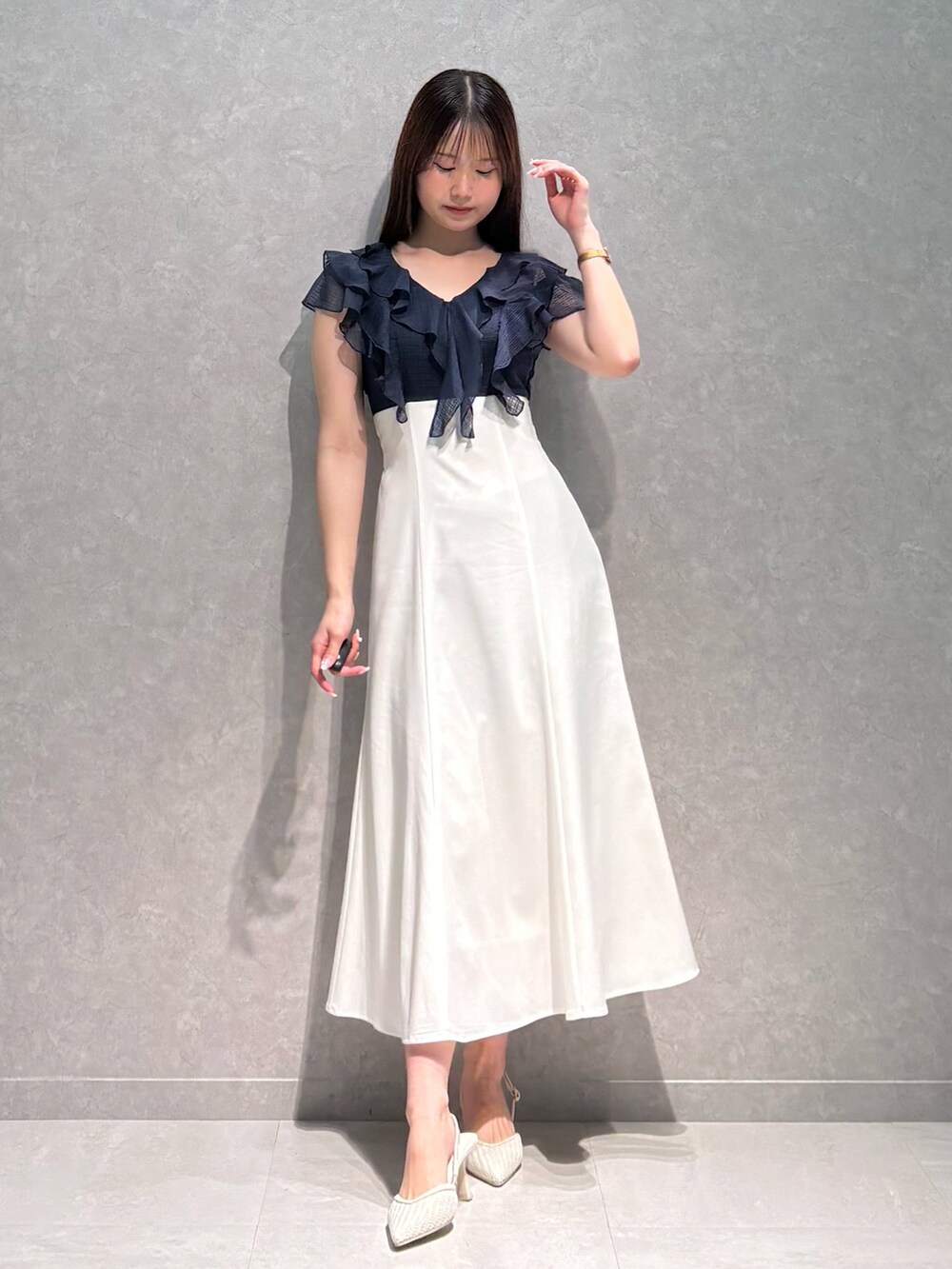 ブルー系のワンピース、ホワイト系のパンプスを着用したレディースの春コーディネートの2枚目の写真