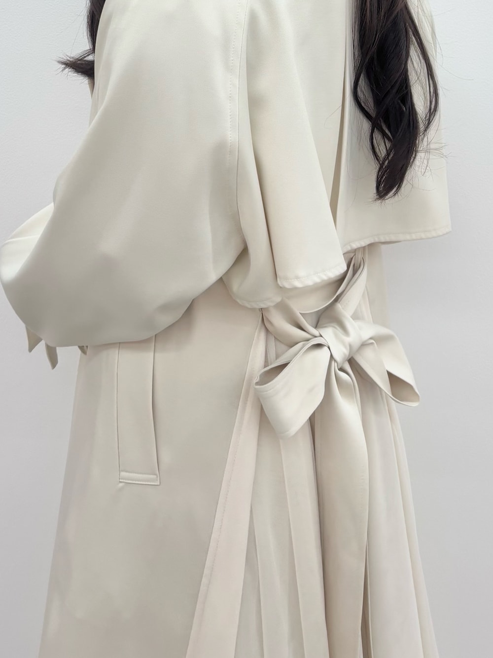 ブラック系のブーツ、グレー系のニット/セーター、ホワイト系のトレンチコートを着用したレディースの冬コーディネートの6枚目の写真