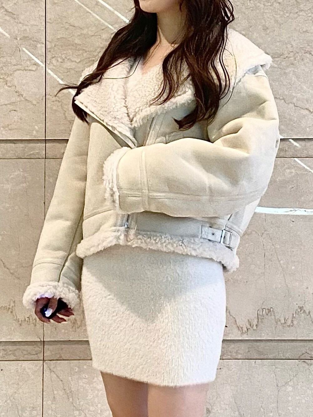 ホワイト系のムートンコート、ホワイト系のワンピース、ブラウン系のブーツを着用したレディースの秋コーディネートの2枚目の写真